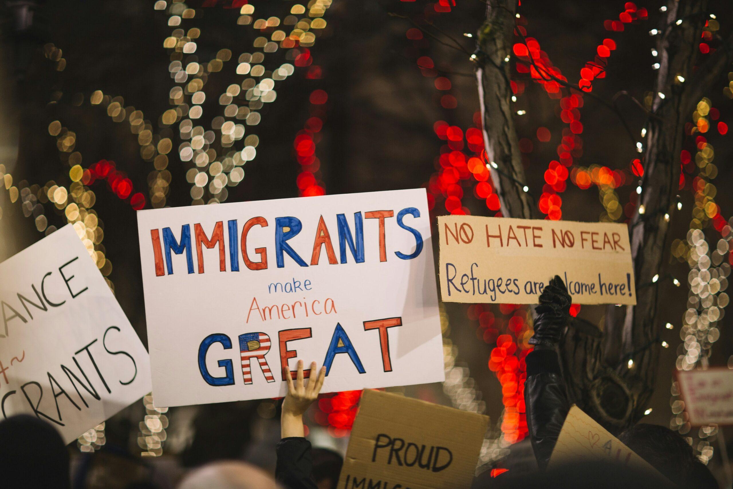 people in a crowd holding pro-immigration signs